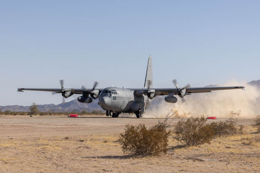 Een C-130 landt op een onverharde landingsbaan.