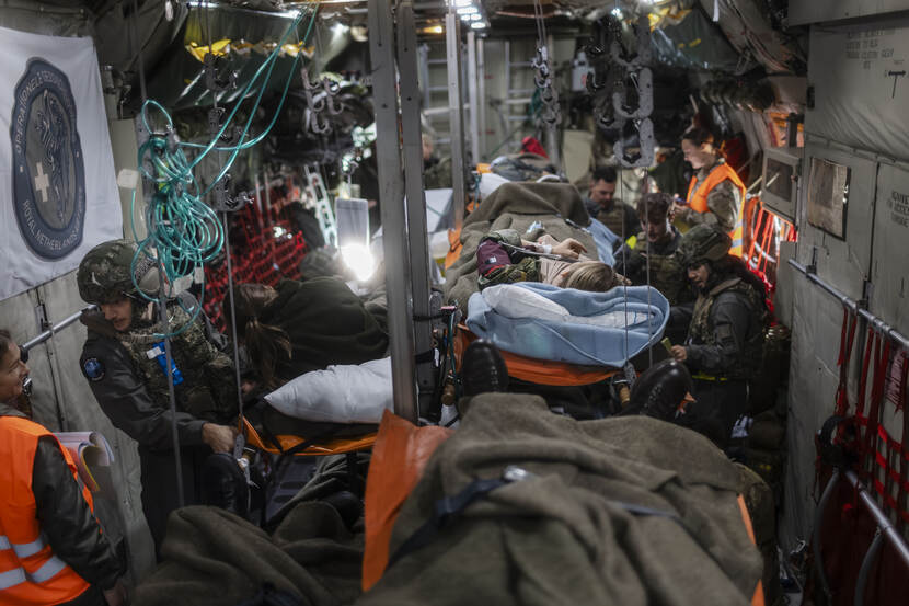 Een militair vliegtuig vol met slachtoffers op brancards en militair medisch personeel.