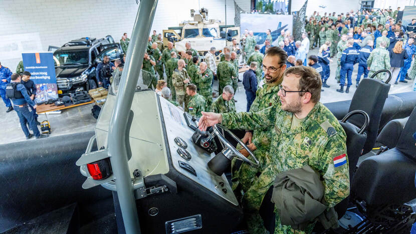Twee militairen achter het stuur van een boot.