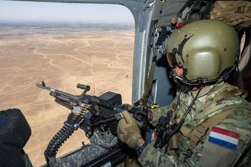 Doorgunner boven een zandvlakte.