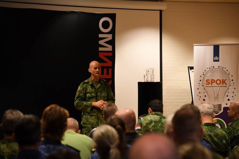 Veraart spreekt voor een zaal met militairen en burgers.