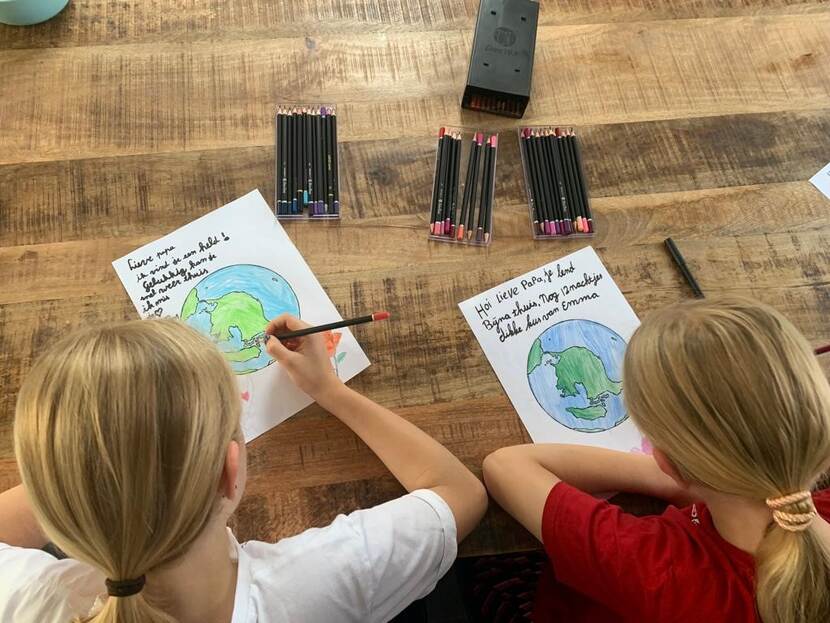 Foto van kinderen die een kleurplaat inkleuren.