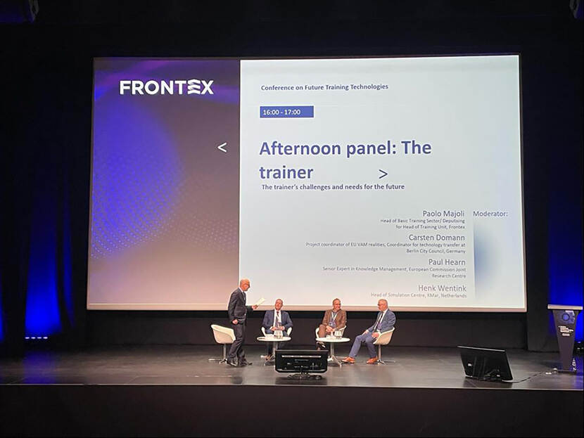 Vier deelnemers aan symposium Frontex zitten op het podium voor een paneldiscussie.