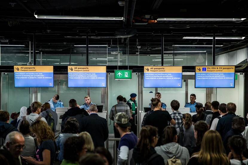 Marechaussees controleren paspoorten op luchthaven.