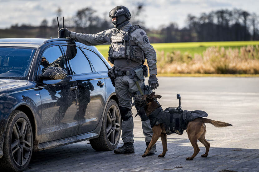 een AT’er die op het dak van zijn auto communicatie-apparatuur bedient.