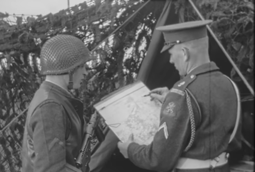 Zwart-witfoto van marechaussee die praat met een militair.