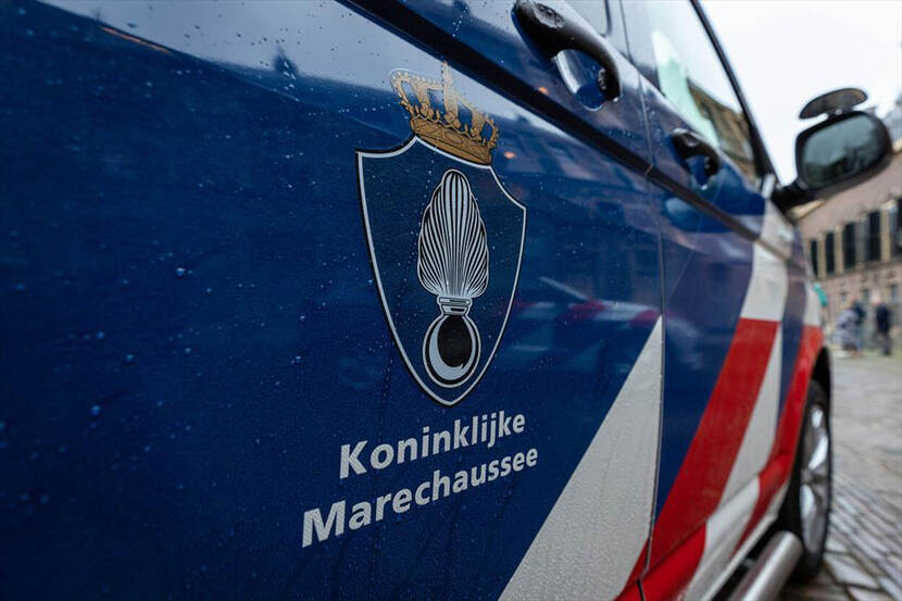 Het logo van de Marechaussee op de deur van een dienstwagen