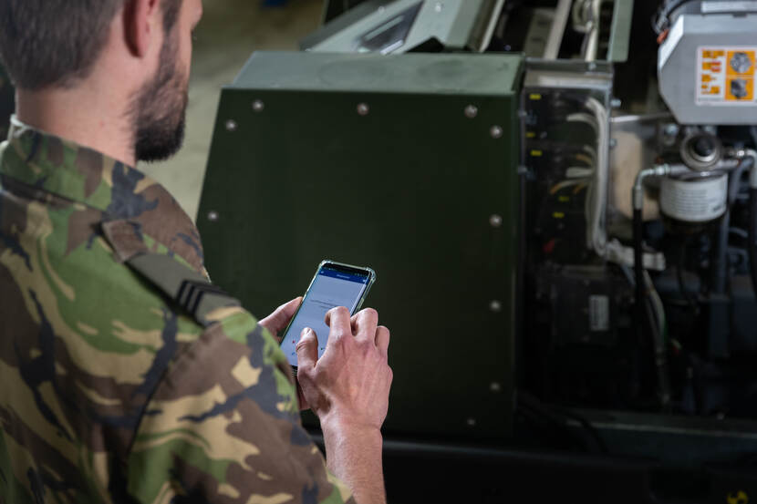 Luchtmachtmilitair met een smartphone op locatie.
