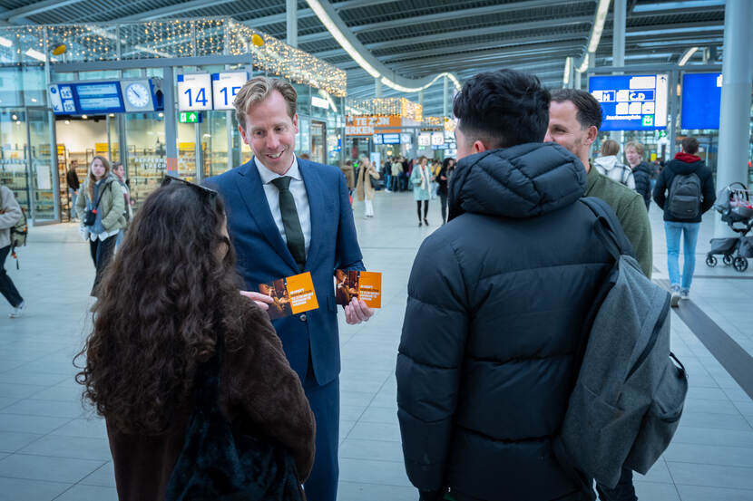Staatssecretaris Christophe van der Maat deelt flyers uit op Utrecht Centraal