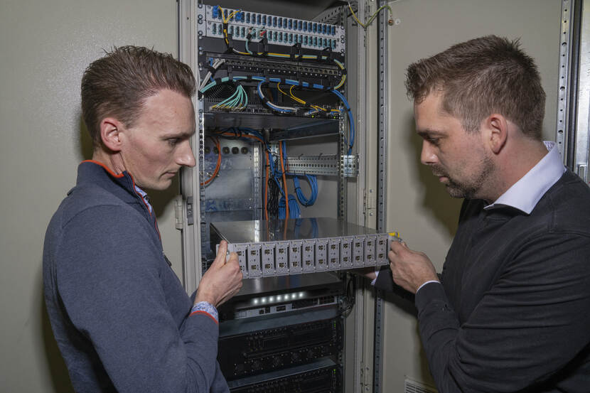 Teun de Groot en Tim de Wolf plaatsen een module met datadiodes in een serverrek