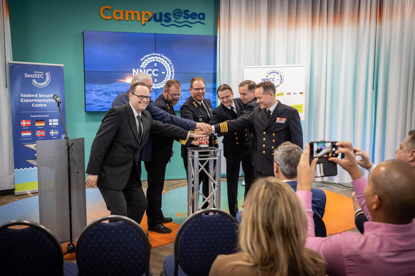 Zeven afgevaardigden van het SeaSEC drukken symbolisch op een knop om het Seabed Security Experimentation Centre te openen.