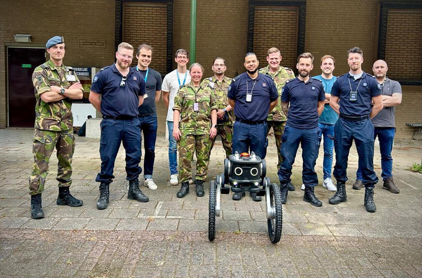 Groep mensen met robot ervoor.