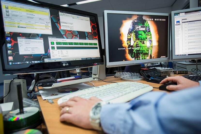 een burgermedewerker zit achter een pc te werken.