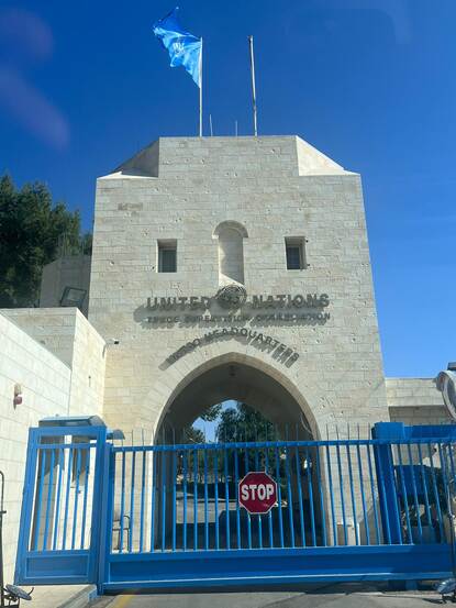De witstenen toegangspoort tot het VN-hoofdkwartier UNTSO heeft een grote boog met daarvoor een hoog blauw hekwerk.