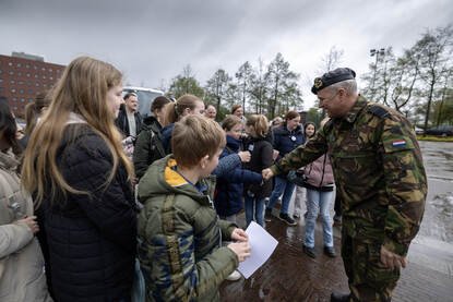 Commandant der Strijdkrachten Onno Eichelsheim begroet een groep kinderen op de Van Ghentkazerne in Rotterdam