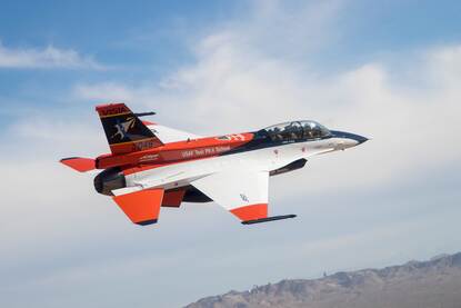 De in speciale kleuren geschilderde F-16 in vlucht.