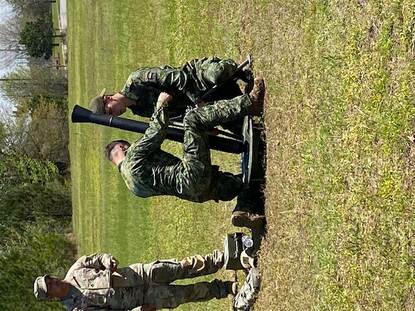 Nederlandse militairen in uniform brengen een mortier in stelling.