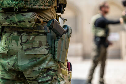 Een been van een militair met een Glock-handwapen in de holster geborgd.
