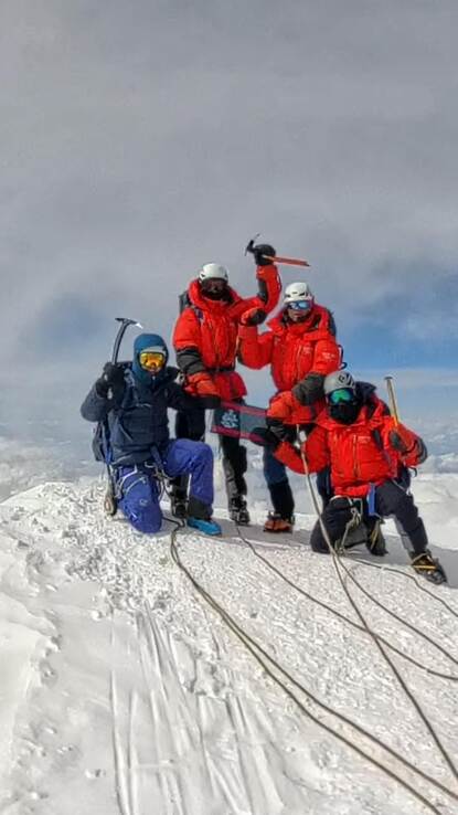 Juichend viertal op de top van de berg met de handen in de lucht.