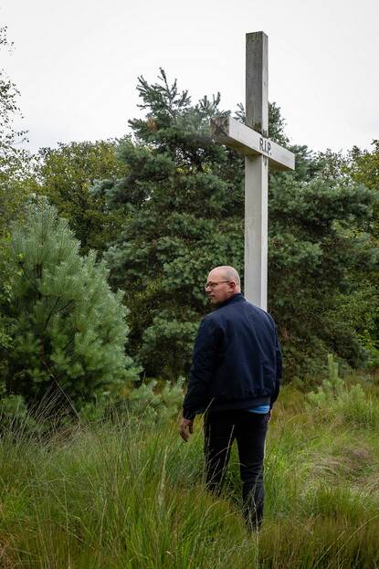 Van Loo loopt langs het witte gedenkkruis.