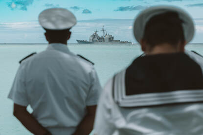 Marinepersoneel in witte uniformen bekijken één van de schepen voor de kust van Pearl Harbour in Hawaii.