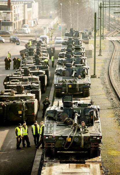 staande foto van defensiematerieel dat naast een spoor klaar staat voor vertrek.