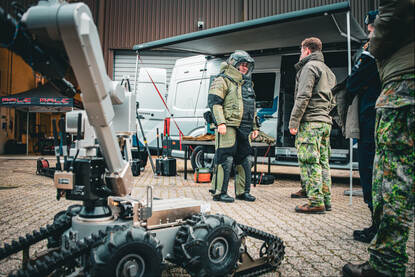 De Commandant der Strijdkrachten loopt in een bompak.