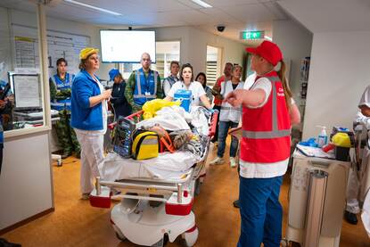 Verschillende hulpverleners staan rond een ziekenhuisbed in het Calamiteitenhospitaal. Op het bed ligt patiënt met fictieve verwondingen.