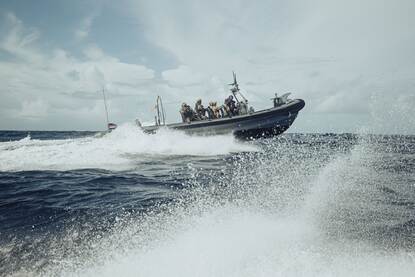 Militaire bemanning in een rubberen patrouilleboot op woeste zee