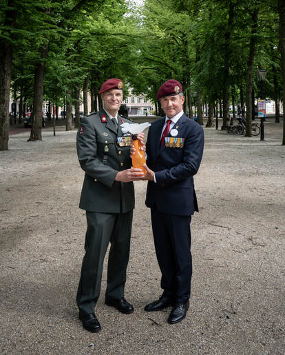 Links sergeant-majoor Patrick de Groot en rechts Henk Tukker met de Witte Anjerprijs in handen