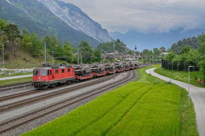 een trein beladen met Leclerc gevechtstanks rijdt tussen de Alpen door.