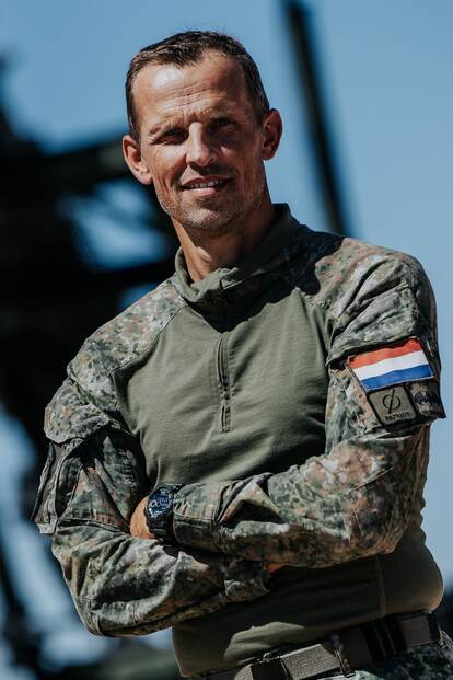 Een militair met zijn armen over elkaar.