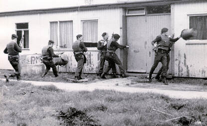 Links: Groep militairen probeert via deur gebouw binnen te komen. Rechts: 5 militairen staan naast elkaar tegen een muur en houden de oren dicht als een deur eruit wordt geblazen. Bijschrift: De BSB was aanvankelijk ‘overal’ van. De brigade bestaat nu uit allround getrainde operators met individuele specialisaties.