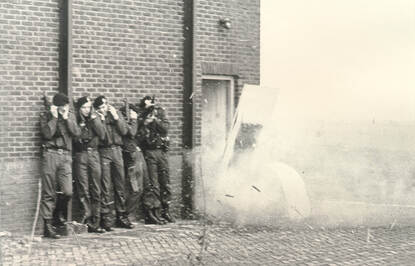 Links: Groep militairen probeert via deur gebouw binnen te komen. Rechts: 5 militairen staan naast elkaar tegen een muur en houden de oren dicht als een deur eruit wordt geblazen. Bijschrift: De BSB was aanvankelijk ‘overal’ van. De brigade bestaat nu uit allround getrainde operators met individuele specialisaties.