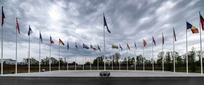 Het plein met daarop de 32 vlaggen van de lidstaten van de NAVO.