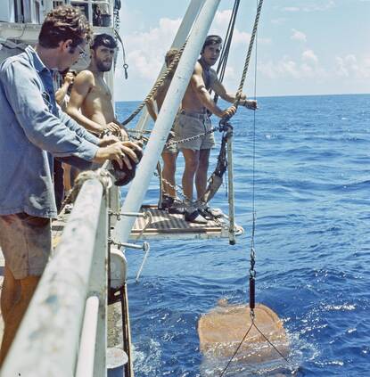 Personeel van de Hydrografische Dienst haalt monsters van de zeebodem naar boven.