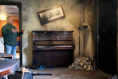 Michael Leenhouwers staat in het nieuwe house of practice, naast een gesloopte piano.