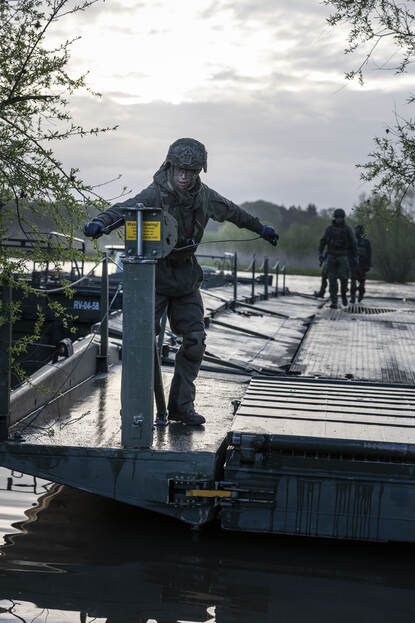 Soldaat 1-Giovanni is op een van de onderdelen van de brug aan het werk.
