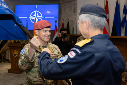 Luitenant-generaal Schreurs neemt met het aanpakken van de NAVO-vlag het commando over de missie over.