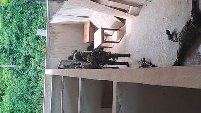 Ivoriaanse special forces lopen door een schiethuis van hout.