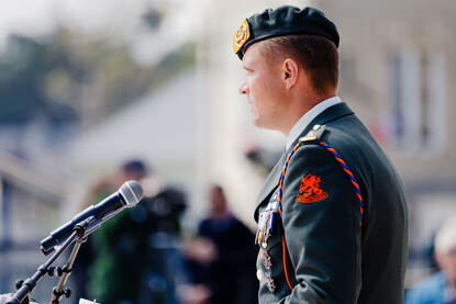 itenant-kolonel Niels Verhoef geeft een toespraak en praat in een microfoon.
