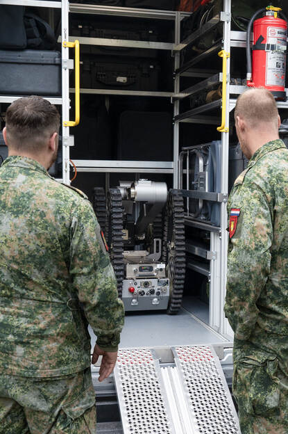 Een robot van de EOD wordt achterin de bus gemanoeuvreerd.