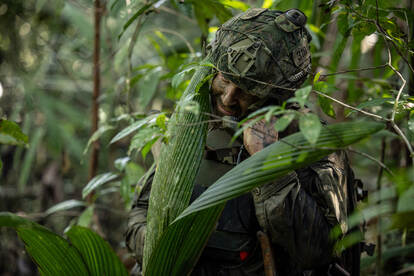 Een militair met radio in de jungle.