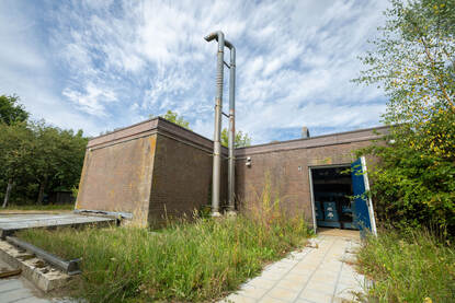 Bakstenen gebouw zonder ramen met een geopende deur.