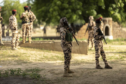 Tsjadische militairen met een wapen en in een auto.