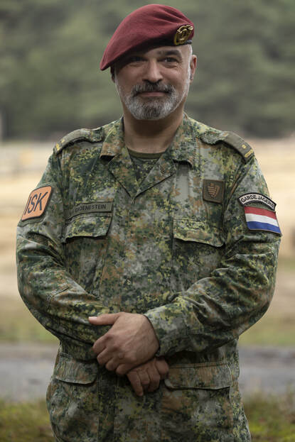 de majoor staand en lachend.