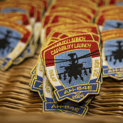 Een stapel badges van de capability launch AH-64E.