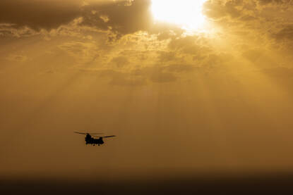 Chinook vliegend boven Irak bij ondergaande zon.