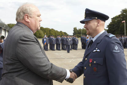Links: het opspelden van de medaille. Rechts: de medaille in close up.