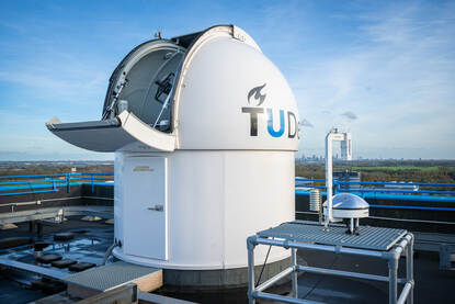 Witte koepel met open klep waarin telescoop zit.